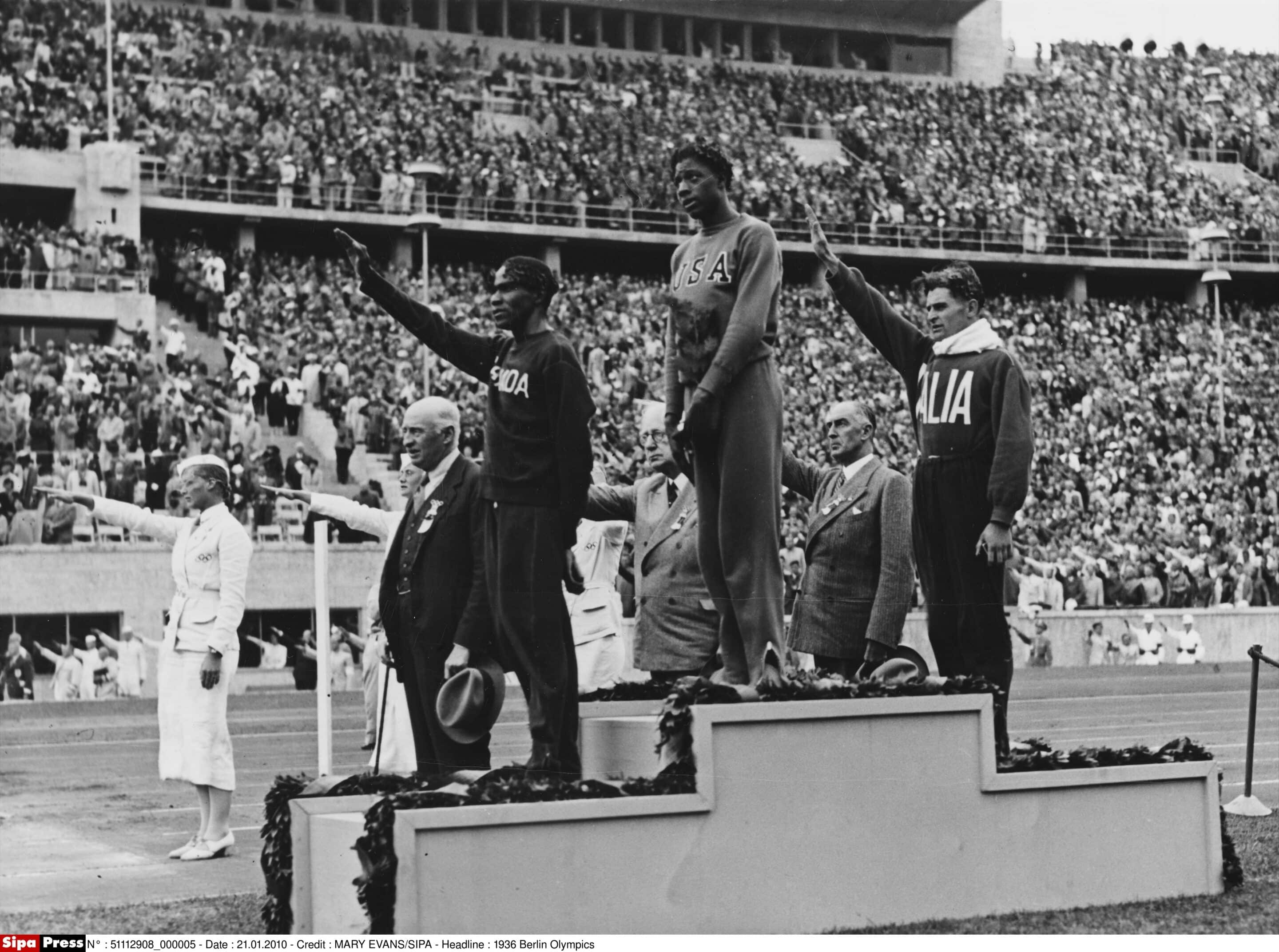 Winners of the 800 metres race on the winner's podium at the 1936 Berlin Olympic Games. 1st place, Woodruff of the USA, 2nd Lanci of Italy and 3rd Edwards of Canada.     Date: 1936
